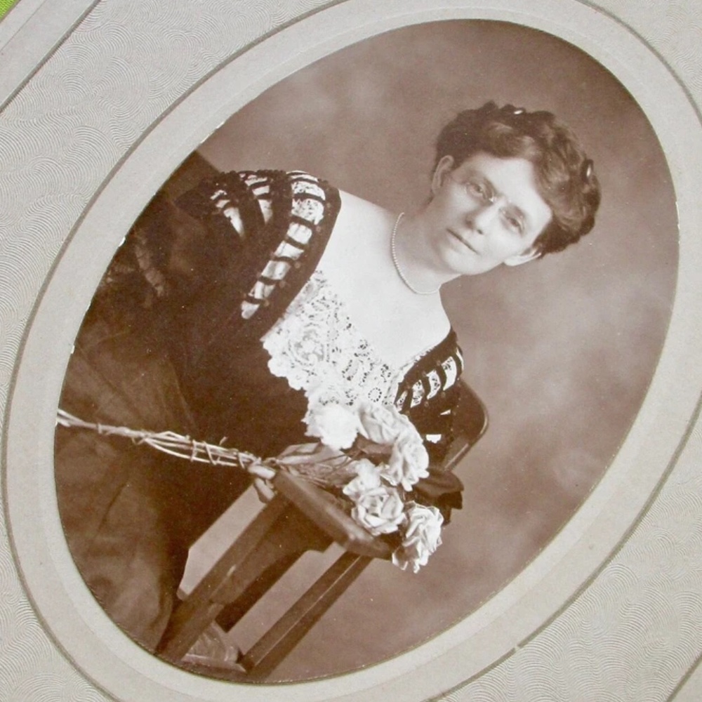 studio portrait Victorian / Edwardian girl in gorgeous dress, braids, glasses